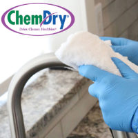 Chem-Dry floor cleaning franchise sanitizing a kitchen faucet